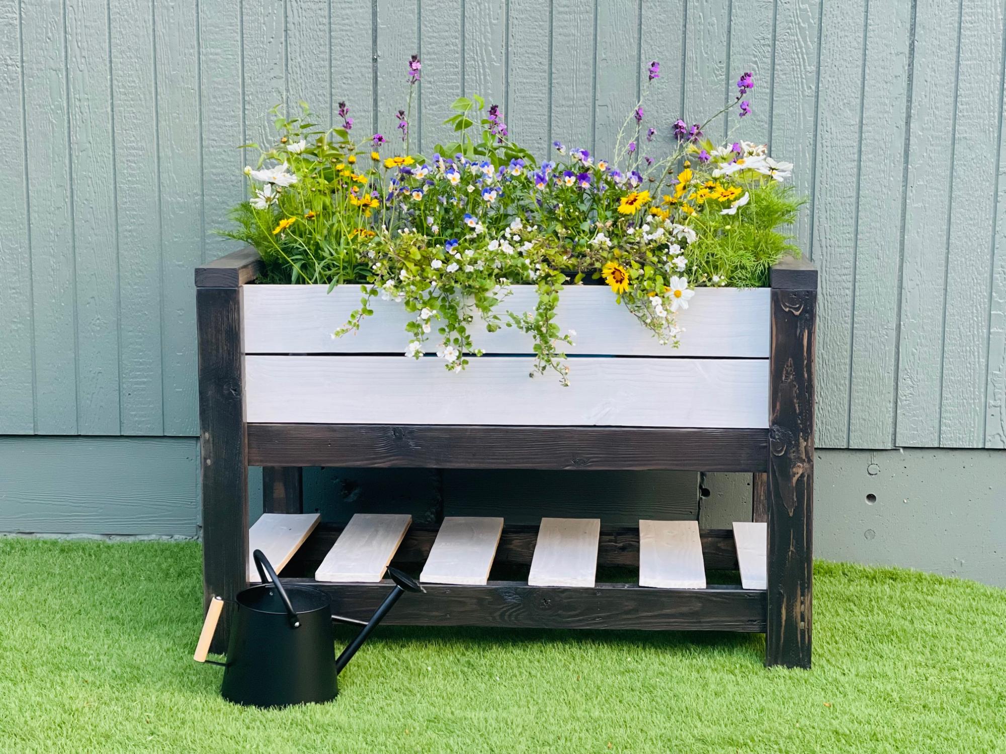 Image of Simple wooden raised planter box with white picket fence