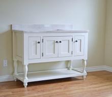 white farmhouse style bathroom vanity with turned legs and open bottom shelf