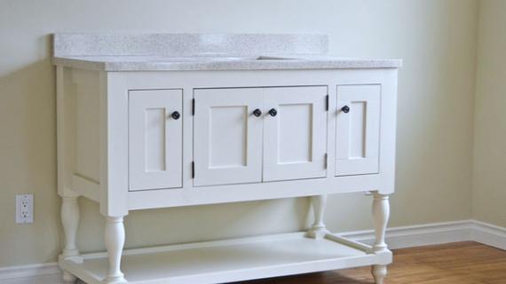 white farmhouse style bathroom vanity with turned legs and open bottom shelf