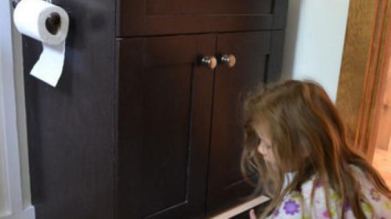 bathroom vanity with little girl pulling out hidden step drawer